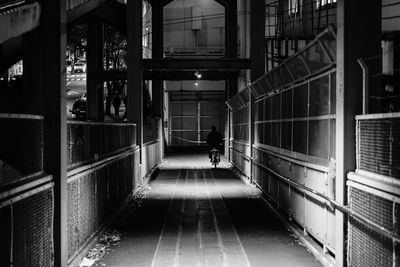 Rear view of person walking in illuminated building