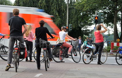 People riding bicycle on street in city