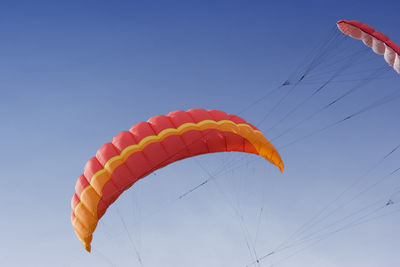 Low angle view of parachutes against clear sky