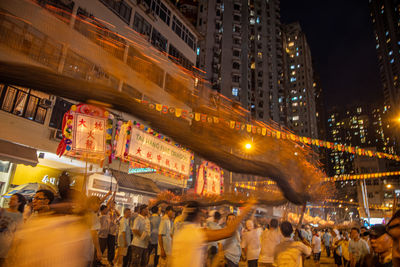 People on illuminated street at night