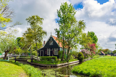 House amidst trees and buildings against sky