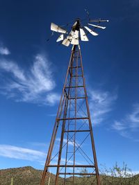 Low angle view of windmill against blue sky