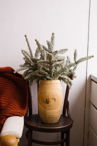 Christmas decor by the sofa. fir branches in a wooden vase