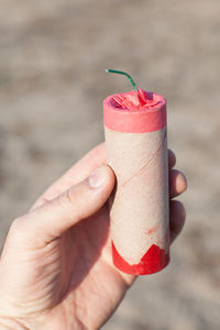 Cropped hand holding cracker outdoors