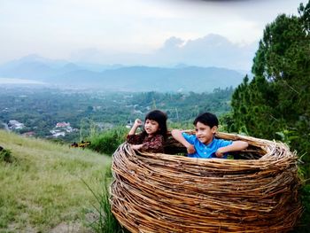 Portrait of woman in basket against mountains