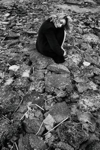 High angle view of man sitting on rock