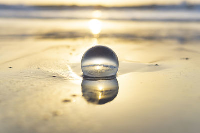 Close-up of glass of water on beach