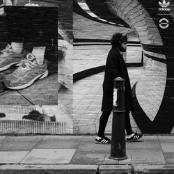 Rear view of woman standing on footpath