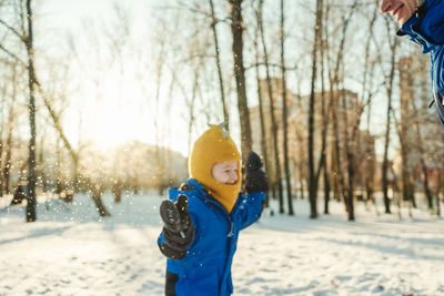 Father and son playing with snow in forest