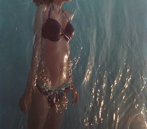 High angle view of woman wearing bikini swimming in sea
