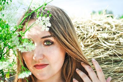 Close-up portrait of young woman with plants