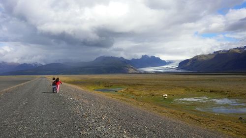 Scenic view of lake and mountains against cloudy sky