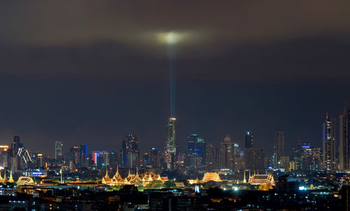 Illuminated cityscape against sky at night