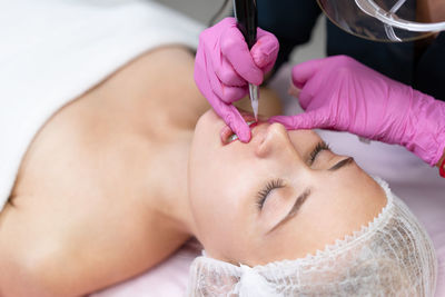 Beautician applying make-up to woman