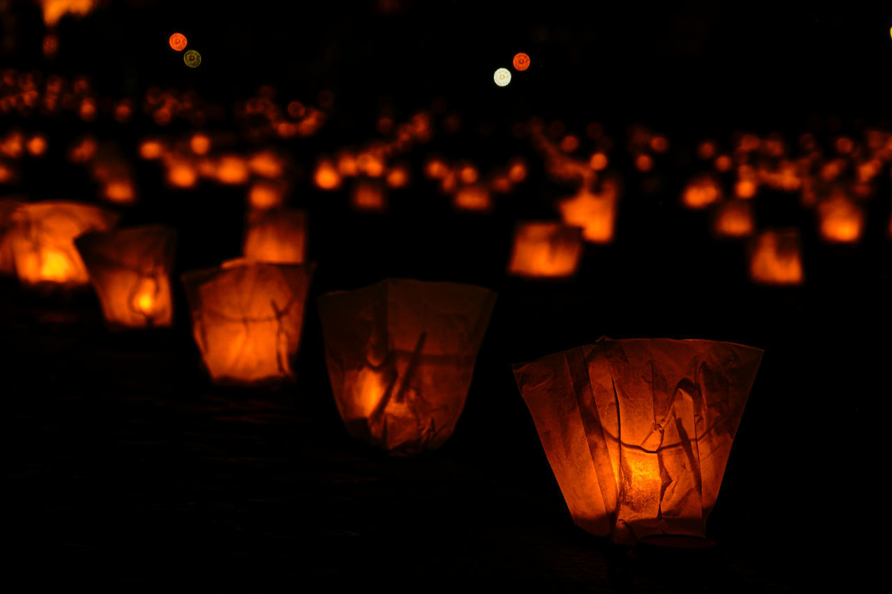 lantern, illuminated, lighting, darkness, lighting equipment, night, celebration, no people, tradition, candle, light, focus on foreground, chinese lantern, traditional festival, orange color, nature, decoration, dark, food and drink, glowing, outdoors, large group of objects, burning, pumpkin, event, close-up