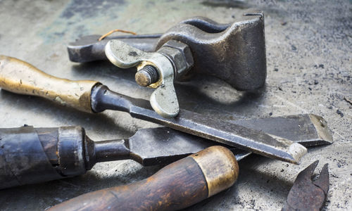 Close-up of various rusty tools on metal table