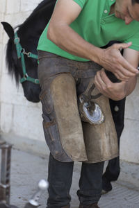 Farrier bending down horse shoe