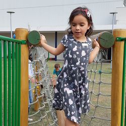 Cute girl on play equipment at park