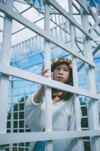 Portrait of woman standing by metallic built structure