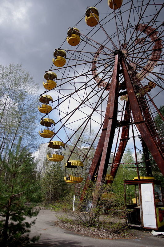 LOW ANGLE VIEW OF CROPPED FERRIS WHEEL AGAINST CLOUDS