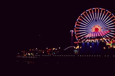 Low angle view of illuminated ferris wheel at night