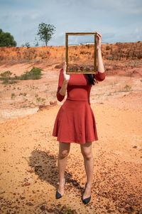 Young woman standing against rock