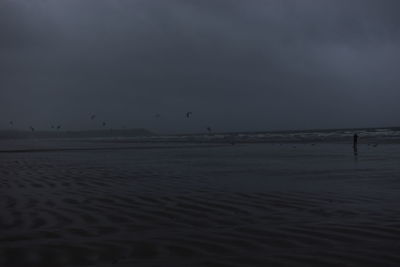 Scenic view of beach against sky at dusk