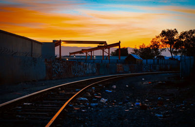 Railroad tracks against sky during sunset