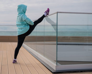 Full length of woman exercising on window