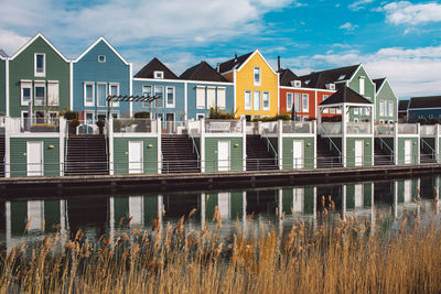 Buildings by lake against sky