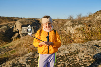 Portrait of young man standing on rock