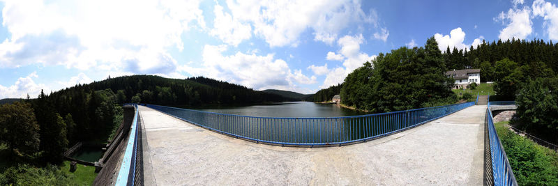 Bridge over river against cloudy sky