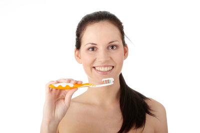 Portrait of smiling woman holding ice cream against white background