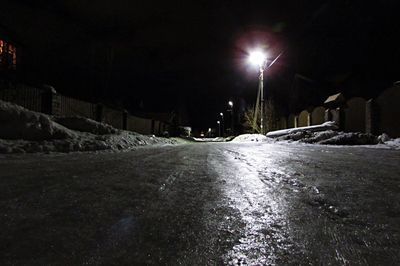 Snow covered illuminated road at night