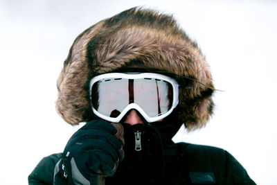 Portrait of woman wearing ski goggles against clear sky