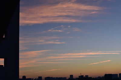 Modern cityscape against sky during sunset