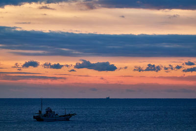 Sailboat sailing on sea against sky during sunrise