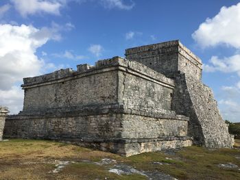 Low angle view of old building against cloudy sky