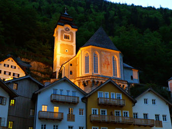 Beautiful church and traditional houses on the hillside at the dusk of hallstatt, austria