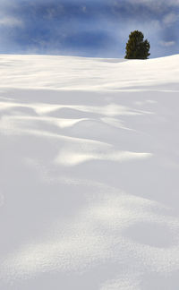 Scenic view of snow covered land against sky