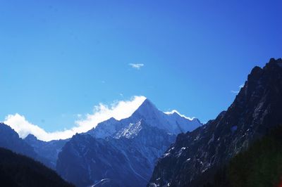 Scenic view of snowcapped mountains against blue sky