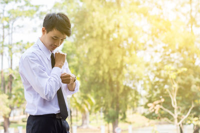 Young businessman buttoning cuff