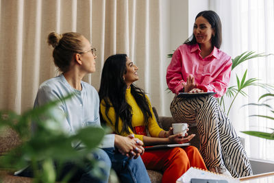 Female entrepreneurs discussing while sitting together at office