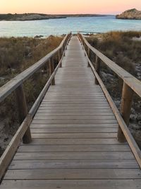 View of wooden footbridge leading to sea