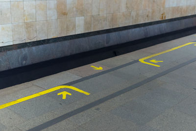 High angle view of yellow arrow symbol on road