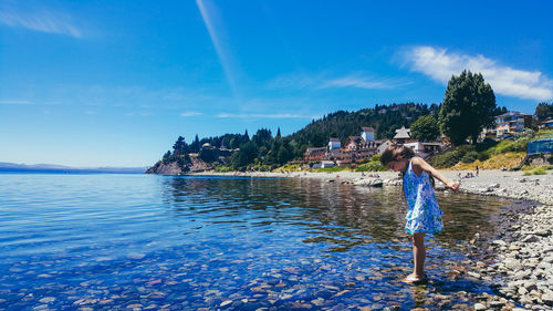 Girl by sea against blue sky