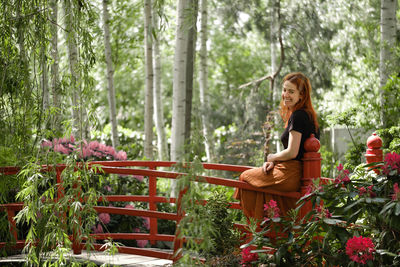 Happy ginger hair woman in well-groomed park or garden. freedom and healthy way of life. female in