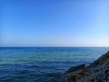 Scenic view of sea against clear blue sky