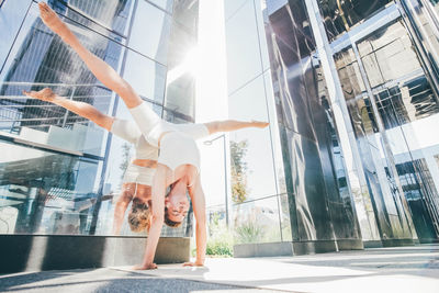 Low angle view of young woman standing against sky