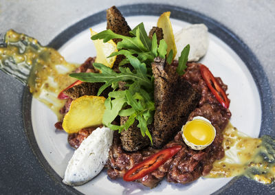 High angle view of beef tartare with truffle cheese in plate